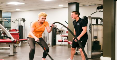 Das Sporthotel Bruurs ist ein modernes zweist&ouml;ckiges Geb&auml;ude mit gelben D&auml;chern und Wellness-Schildern, umgeben von gr&uuml;nen Hecken und B&auml;umen in Baarle-Nassau unter einem teilweise bew&ouml;lkten Himmel - ideal f&uuml;r ein Trainingslager.