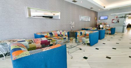 Ein hohes, gelbes Hotel Sol Guadalmar mit Balkonen blickt auf einen klaren, blauen Au&szlig;enpool, umgeben von Palmen und gr&uuml;nen Rasenfl&auml;chen unter einem sonnigen Himmel - perfekt f&uuml;r Ihren Aufenthalt in diesem zentrumsnahen 4 Sterne Hotel Malaga.