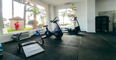 Ein hohes, gelbes Hotel Sol Guadalmar mit Balkonen blickt auf einen klaren, blauen Au&szlig;enpool, umgeben von Palmen und gr&uuml;nen Rasenfl&auml;chen unter einem sonnigen Himmel - perfekt f&uuml;r Ihren Aufenthalt in diesem zentrumsnahen 4 Sterne Hotel Malaga.