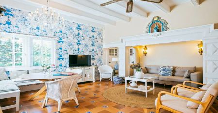 Das Van der Valk Hotel BARCAROLA ist ein 4-Sterne-Hotel im mediterranen Stil an der Costa Brava mit Balkonen mit Fahnen, einem klaren blauen Pool, Pooltischen mit Sonnenschirmen und Palmen unter einem strahlend blauen Himmel.
