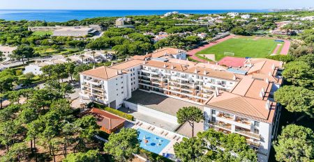 Luftaufnahme des Victoria Sports & Beach Hotels, einer modernen Anlage mit Pool, umgeben von Pinien in Albufeira, in der Nähe von Sportplätzen für Fußball-Trainingslager und unweit der sonnigen Küste.