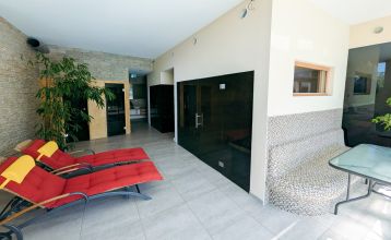 Das Hotel-Restaurant Schachenwald ist ein leuchtend gelbes, zweistöckiges Gebäude mit rotem Ziegeldach vor blauem Himmel – ideal für Trainingslager –, mit Topfpflanzen am Eingang und Autos, die auf der gepflasterten Zufahrt geparkt sind.