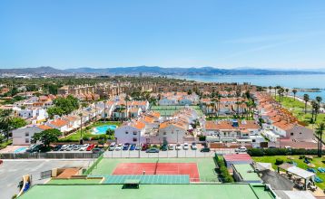 Ein hohes, gelbes Hotel Sol Guadalmar mit Balkonen blickt auf einen klaren, blauen Außenpool, umgeben von Palmen und grünen Rasenflächen unter einem sonnigen Himmel - perfekt für Ihren Aufenthalt in diesem zentrumsnahen 4 Sterne Hotel Malaga.