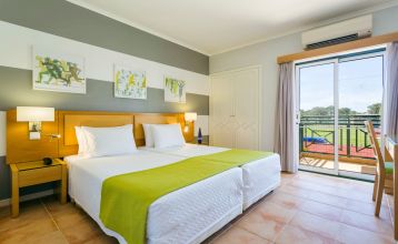 Luftaufnahme des Victoria Sports & Beach Hotels, einer modernen Anlage mit Pool, umgeben von Pinien in Albufeira, in der Nähe von Sportplätzen für Fußball-Trainingslager und unweit der sonnigen Küste.