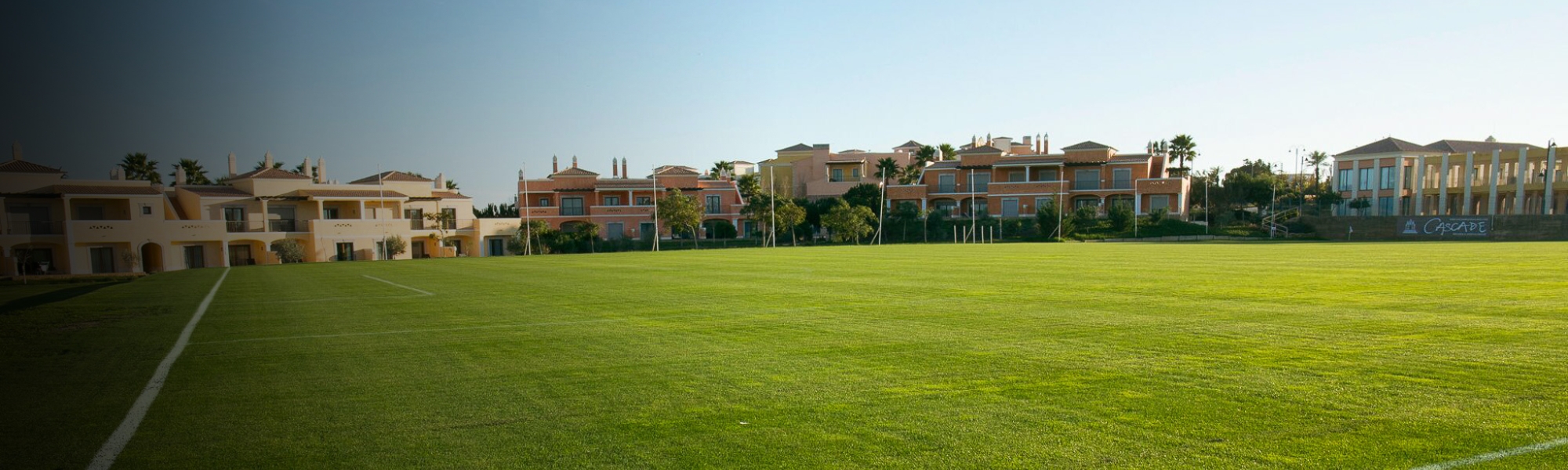 Fußballplatz in der Algarve mit direkter Hotelanbindung und Palmen im Hintergrund.