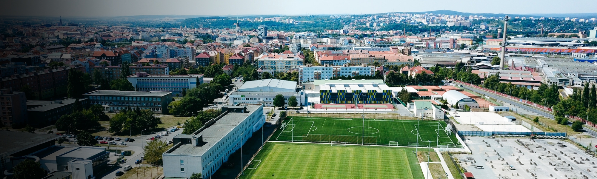 Fußballtrainingsanlage in einer Stadtlandschaft, mit mehreren Fußballfeldern und modernen Einrichtungen.
